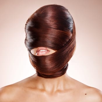 Head, haircare and salon with a model woman in studio on a pink background wrapped in her own hair. Beauty, hairdresser or keratin treatment with a young female wrapping her hairstyle around her face.