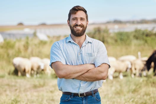 Man, portrait or arms crossed on livestock agriculture, sustainability environment or nature land in ideas, vision or hope. Smile, happy or confident farmer and animals growth or sheep farming.