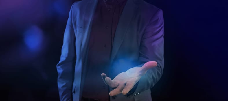 An unrecognizable businessman shows an open palm, demonstrating something invisible.