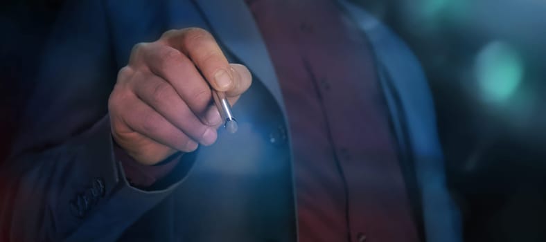 A man in a suit using a stylus to work with an invisible touch screen.