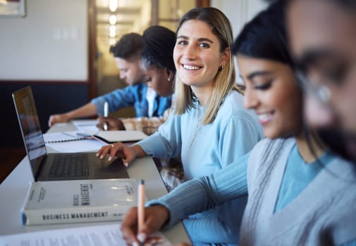 University, education and students in lecture learning and studying business management. College, education scholarship and portrait of happy girl with laptop, books and friends in modern classroom