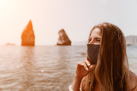 Woman travel sea. Young Happy woman in a long red dress posing on a beach near the sea on background of volcanic rocks, like in Iceland, sharing travel adventure journey