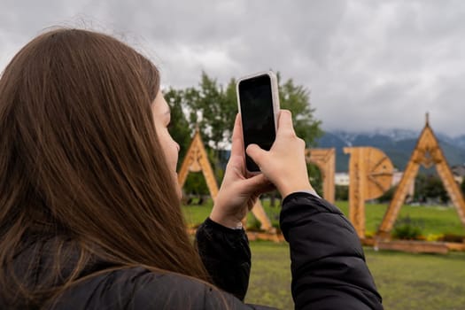 Young woman enjoying nature in Snowy Mountain in Polish Tatry mountains Zakopane Poland. Taking photos shooting video to share in social media. Blogger Naturecore aesthetic beautiful green hills. Mental and physical wellbeing Travel outdoors tourist destination