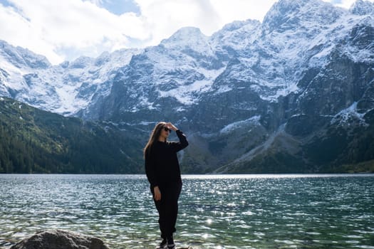 Young woman enjoying nature in Morskie Oko Snowy Mountain Hut in Polish Tatry mountains Zakopane Poland. Naturecore aesthetic beautiful green hills. Mental and physical wellbeing Travel outdoors tourist destination