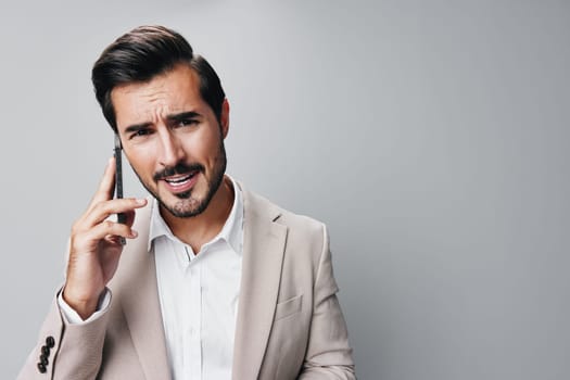 man smile call suit mobile connection phone person confident business technology hold handsome angry cell studio portrait smartphone young online businessman