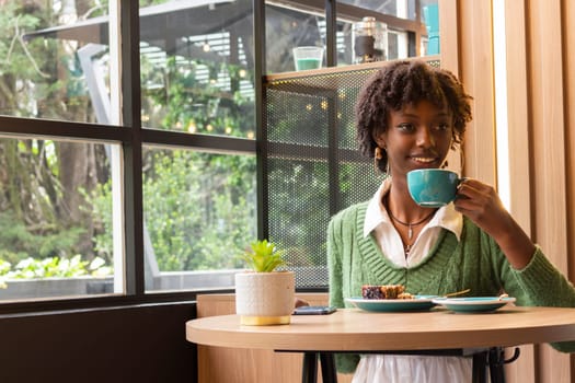 copyspace of black girl having a coffee and enjoying her lifestyle in a trendy cafe. High quality photo