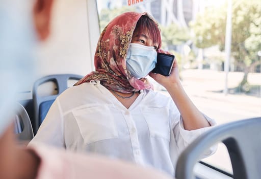Muslim, phone and bus woman in covid face mask talking of travel safety, compliance and health information or networking Islamic, hijab international girl travel on city transport with cellphone call.