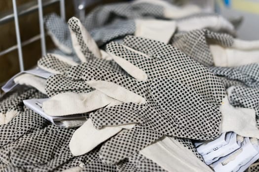 Rubberized grey work gloves hanging on a wall. Part of work-wear and protection equipment.