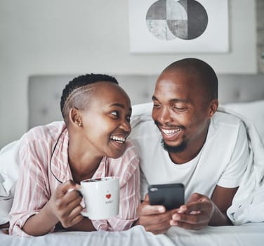 Black couple in bed with smartphone, coffee and happiness with morning routine, social media or streaming online. Wifi, communication and technology with happy man and woman, relax at home together.