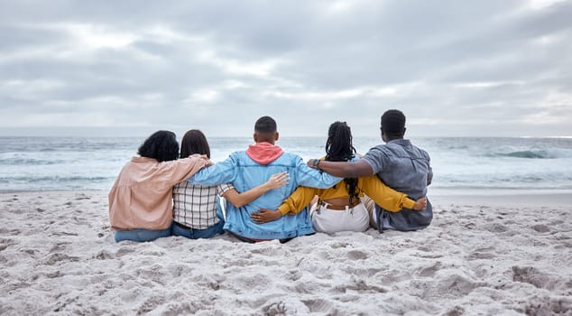 Diversity, hug or friends on beach sand to relax on calm holiday, vacation bonding in nature together. Back view, men and women group relaxing at sea enjoy traveling on ocean trips in Miami, Florida.