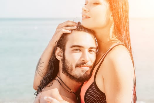 Close up shot of beautiful young caucasian woman with black hair and freckles looking at camera and smiling. Cute woman portrait in a pink bikini posing on a volcanic rock high above the sea