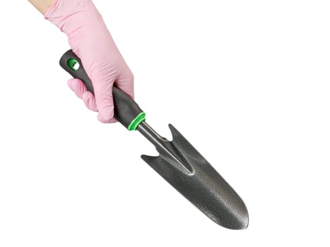 Small garden trowel in woman's hand dressed in a pink rubber glove on the white isolated background.