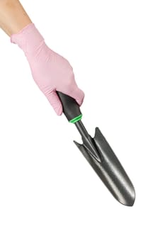 Small garden trowel in woman's hand dressed in a pink rubber glove on the white isolated background.