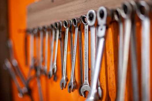 05.17.2023, Kemerovo, Moscow. Keys and work tools hang on the wall in a car repair shop or garage. Dirty, working tool of an auto mechanic