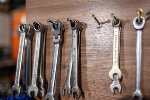 05.17.2023, Kemerovo, Moscow. Keys and work tools hang on the wall in a car repair shop or garage. Dirty, working tool of an auto mechanic