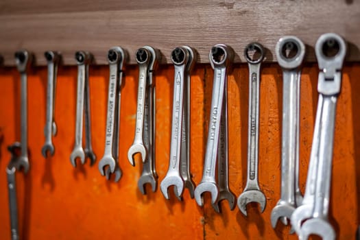 05.17.2023, Kemerovo, Moscow. Keys and work tools hang on the wall in a car repair shop or garage. Dirty, working tool of an auto mechanic