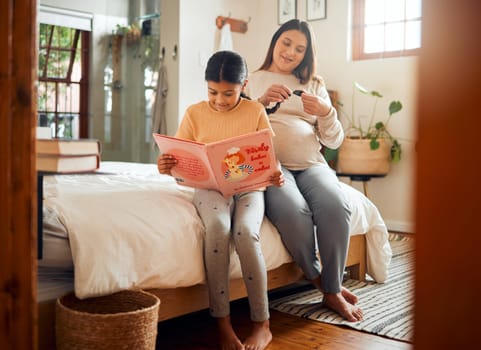 Family, books or education and a girl reading in a bedroom with her mom playing with her hair in their home. Book, learning and love with a mother and daughter bonding while sitting on a bed together.