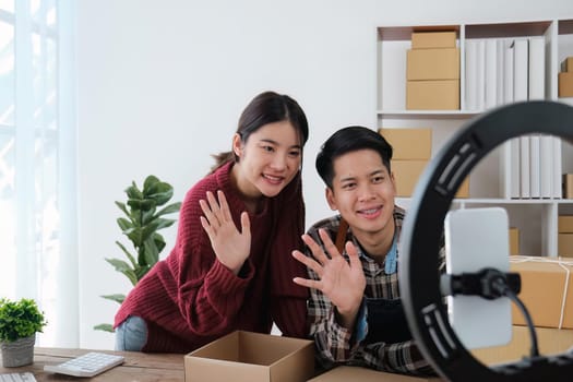 young couple mobile phone recording live streaming in online social media selling products by couple, doing freelance, own business or entrepreneur at home. E-commerce, shopping concept.