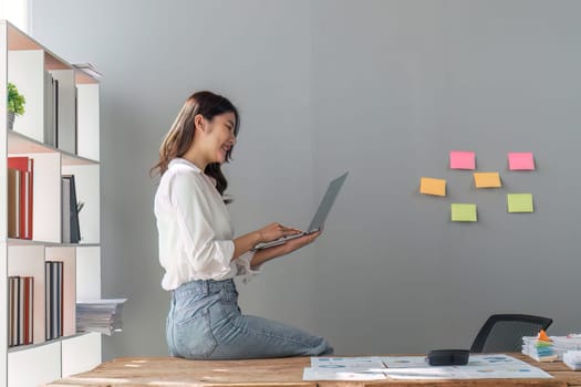 business woman pleased happy cheerful cute beautiful business woman sit in office using laptop computer.