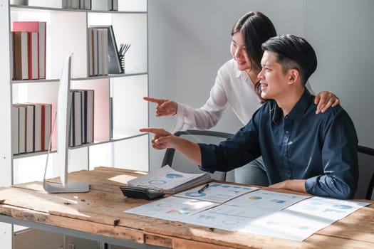 business woman is helping to husband to analyze business . They are analyzing data from graphic charts.