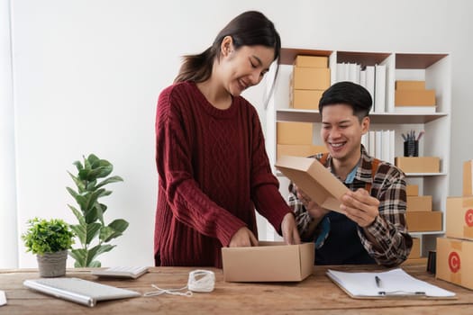 startup small business owner working with computer at workplace. freelance man and woman seller check product order, packing goods for delivery to customer. Online selling, e-commerce.