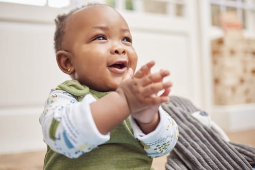 Happy, baby and black child clapping in home, having fun or enjoying time alone. African newborn, children and toddler, kid and young infant play, smile or applause for childhood development in house.