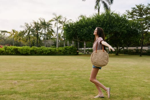 nature woman quiet active bag walk t-shirt natural face lifestyle smiling girl park striped summer bali joy enjoy freedom beautiful meadow