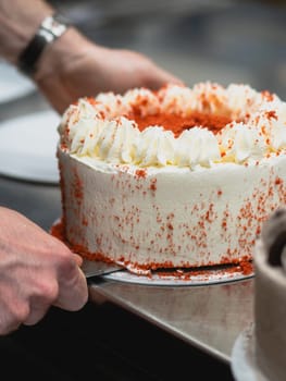 preparing red velvet frosted icing cup cake with sprinkles on top in the kitchen