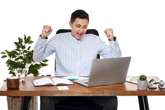 Satisfied businessman gesturing emotionally and celebrating victory in the office