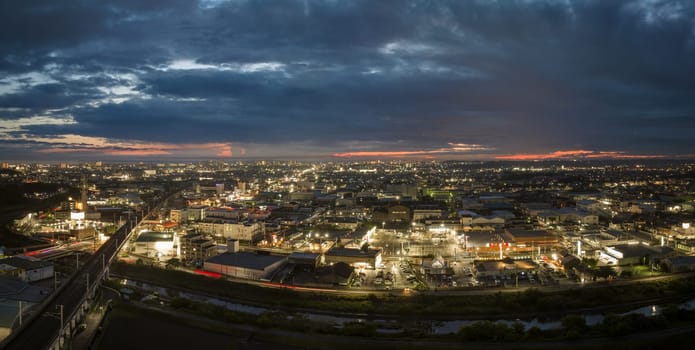 Panoramic aerial view of elevated train tracks and city lights after sunset. High quality photo