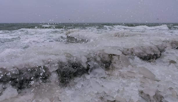 Frozen Black Sea, ice-covered and frozen coastal rocks in the piers, harsh winter