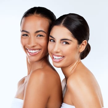 Women friends, studio portrait and cosmetics with smile, beauty and wellness by white background. Lesbian woman, skincare and happy together with excited face, natural glow and isolated for makeup.