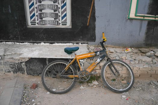 Broken down abandoned bicycle in poor neighbourhood . High quality photo