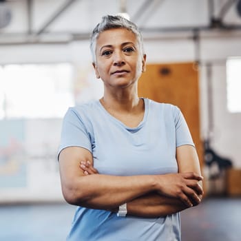 Senior woman, fitness and portrait at gym after exercise, training or workout. Serious old person with arms crossed for health, wellness and motivation or commitment for healthy lifestyle goals.