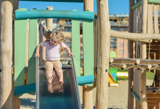 Girl of three years old sliding outdoor Playground