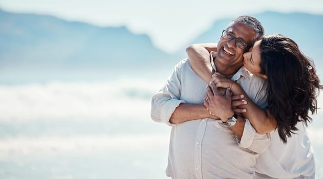 Love, romance and mature couple on beach, embrace and kiss with happy relationship and mockup. Romantic retirement vacation, senior woman and man hugging on tropical ocean holiday travel with smile