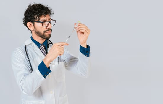 Young doctor drawing medicine from a vial with copy space. doctor drawing medicine from a vial. Concept of doctor with disease antidote