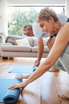 Senior couple, rolling yoga mat and home workout, fitness and exercise on living room floor. Elderly people on lounge ground for pilates training, healthy lifestyle and balance body wellness together.