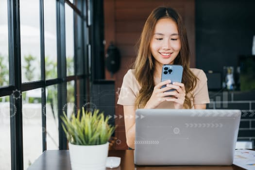 Happy lifestyle female smiling using smartphone in coffee shop, young business woman working with laptop computer she holding smart mobile phone looking out of windows at cefa for texting messages