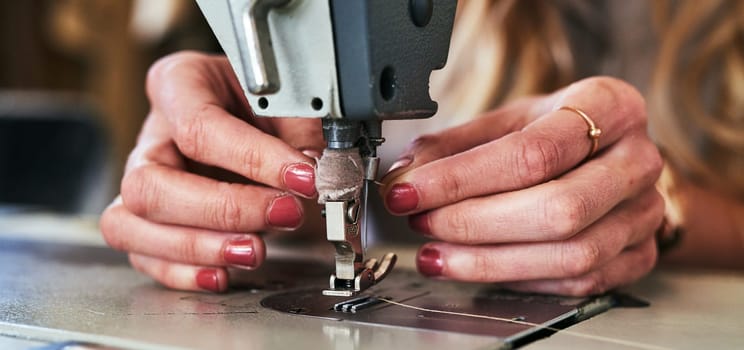 Workshop sewing machine, woman hands and fashion designer with button and thread work. Small business, entrepreneur and female tailor with boutique and employee working with machinery for clothing.