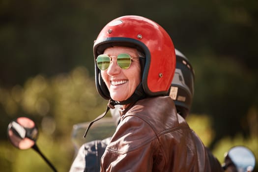 Senior woman, motorcycle road trip and smile with helmet, sunglasses and back for speed, vacation and nature. Elderly lady, happy and travel with motorbike, freedom and fast transportation in summer.