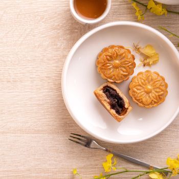 Mid-Autumn Festival holiday concept design of moon cake, mooncakes, tea set on bright wooden table with copy space, top view, flat lay, overhead shot