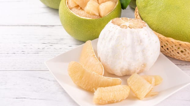Fresh peeled pomelo, pummelo, grapefruit, shaddock on bright wooden table background. Seasonal fruit for Mid-Autumn Festival, close up, copy space.