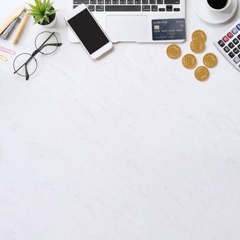 Concept of online payment with credit card with smart phone, laptop computer on office desk on clean bright marble table background, top view, flat lay