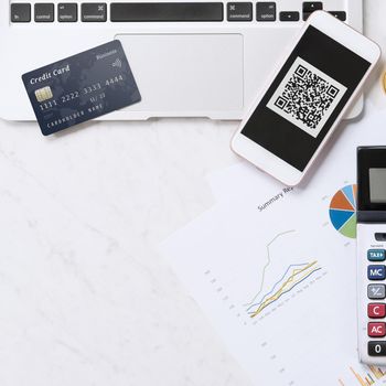 Online payment with QR code concept, virtual credit card, smart phone on office laptop desk on clean marble table background, top view, flat lay