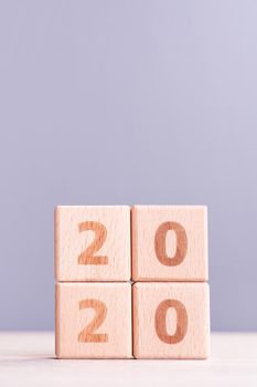 Abstract 2020, 2019 New year target plan design concept - wood blocks cubes on wooden table and pastel blue background, close up, blank copy space.