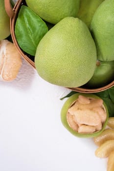 Fresh pomelo, pummelo, grapefruit, shaddock on white cement background in bamboo basket. Autumn seasonal fruit, top view, flat lay, tabletop shot.