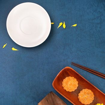 Minimal simplicity layout moon cakes on blue background for Mid-Autumn Festival, creative food design concept, top view, flat lay, copy space.