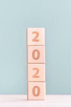 Abstract 2020, 2019 New year target plan design concept - wood blocks cubes on wooden table and pastel green background, close up, blank copy space.