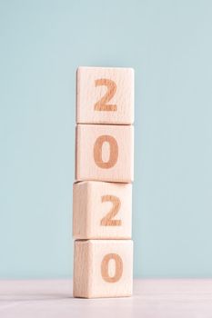 Abstract 2020, 2019 New year target plan design concept - wood blocks cubes on wooden table and pastel green background, close up, blank copy space.